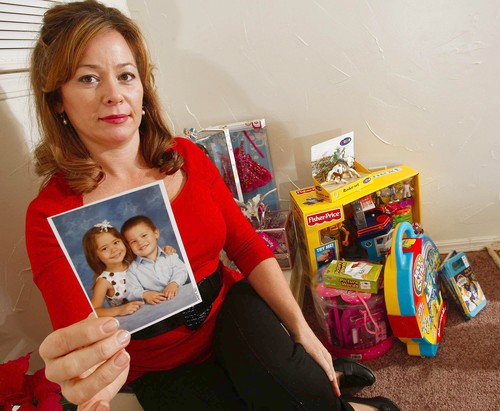 Tamera Jo Freeman holding up a photo of her beloved children. She lost them to a Communist Police State in 2009 for spanking them as any responsible parent would do.